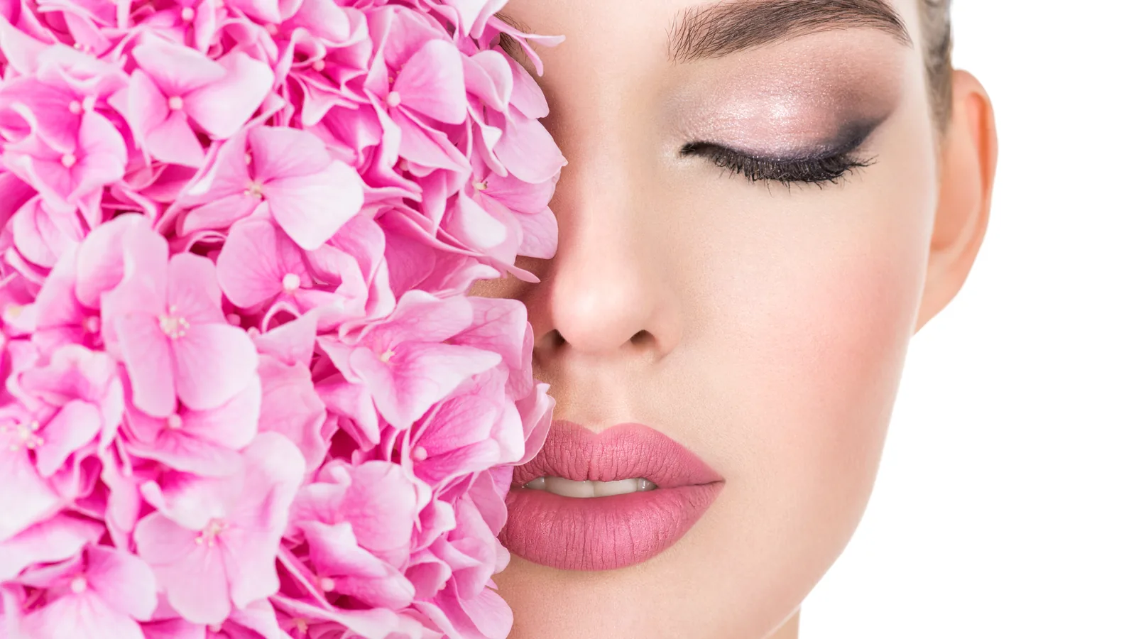 Rosa Hortensienblüte, die eine Gesichtshälfte mit Make-up verdeckt